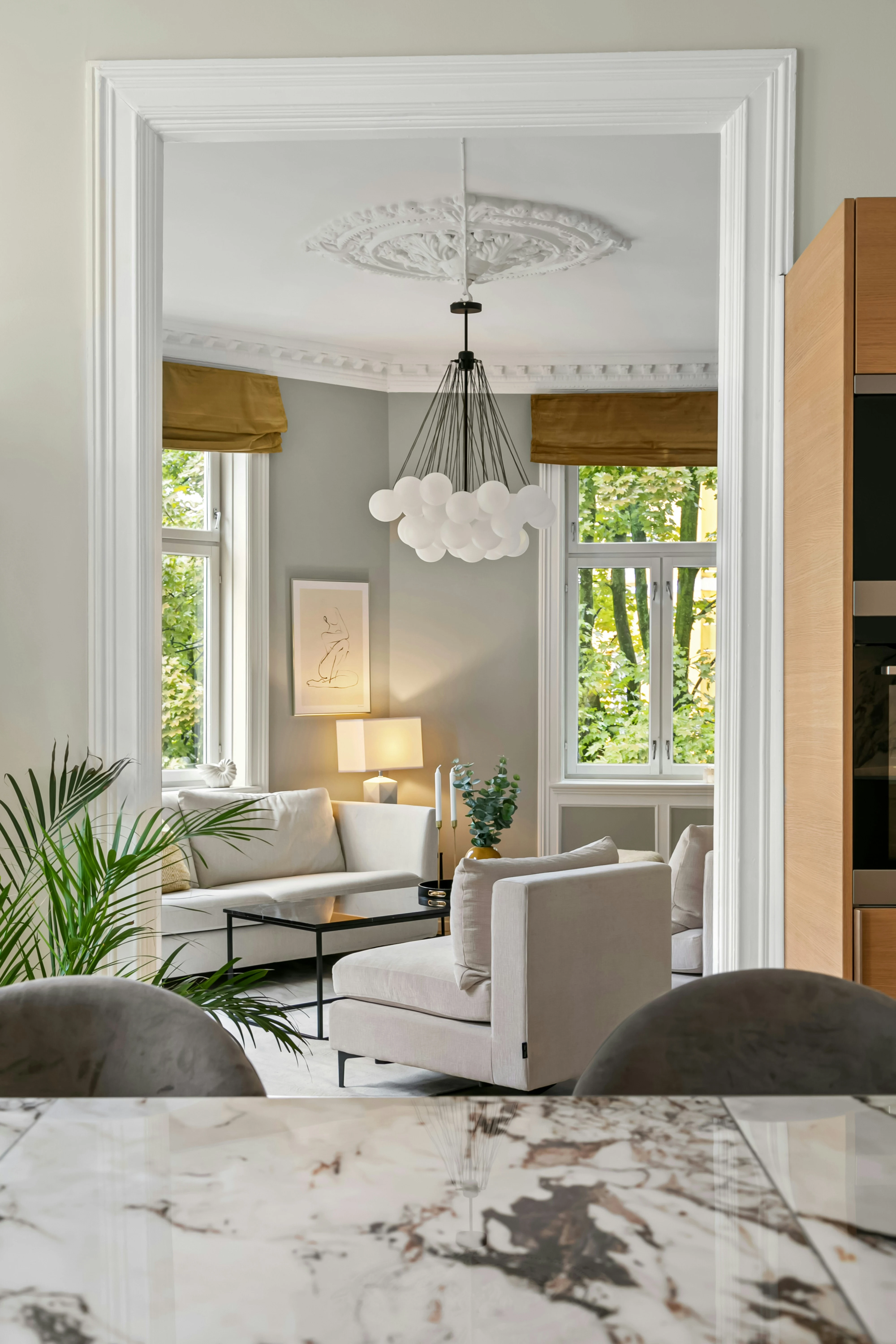 Sunlit living room seen past a polished marble counter